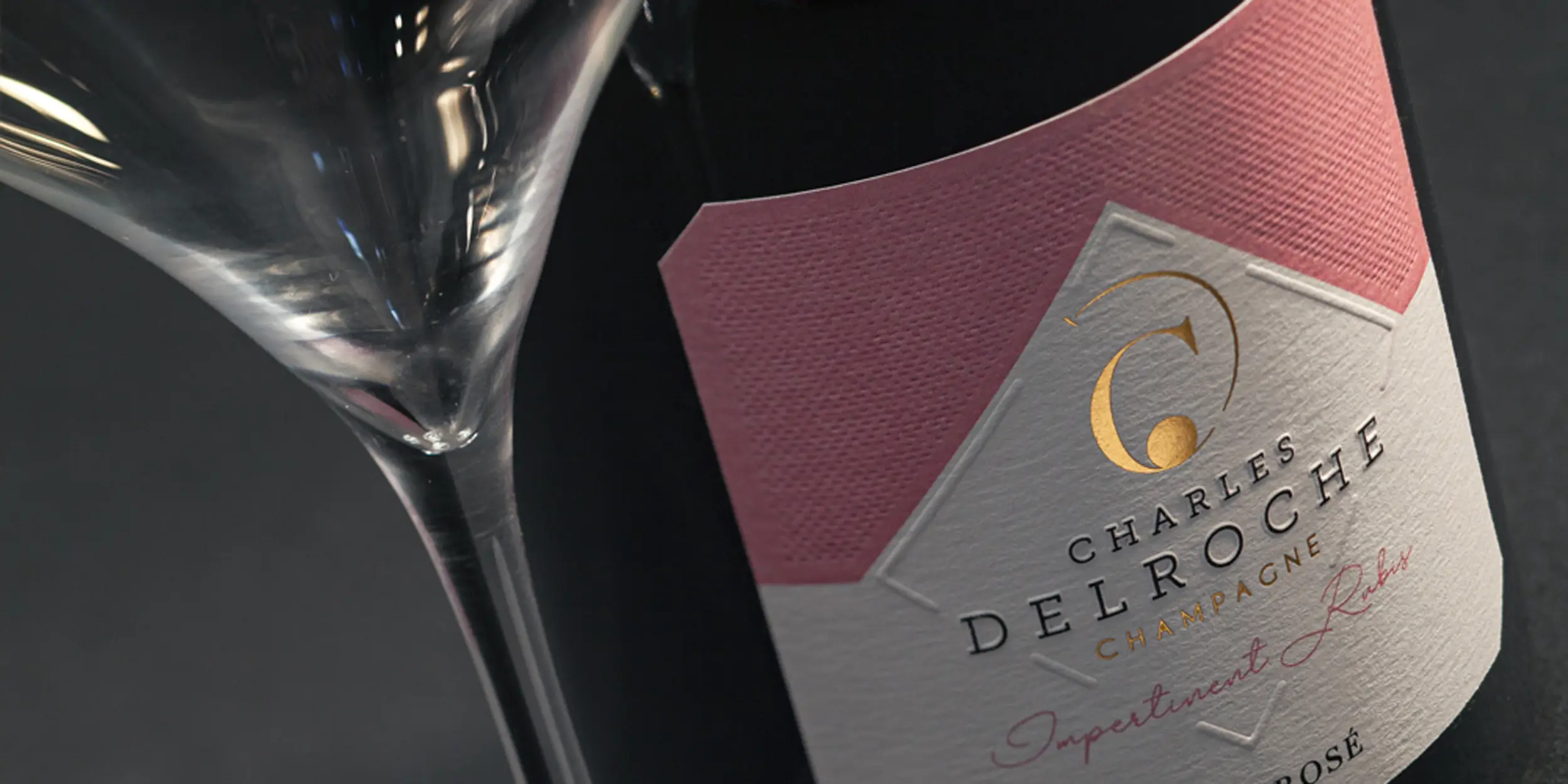 Plan rapproché de la cuvée rosé du Champagne Charles Delroche avec une flûte de Champagne