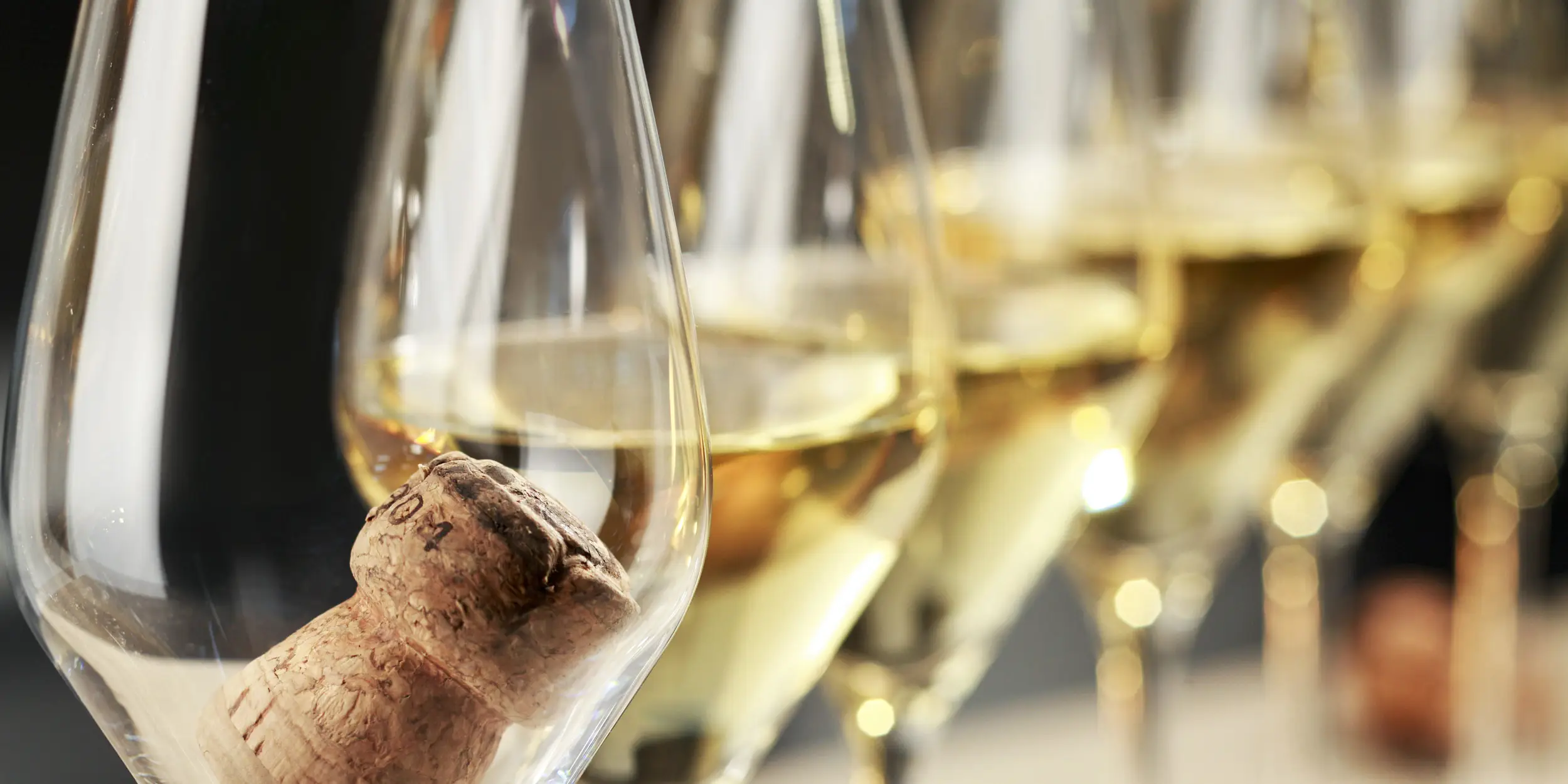 Farandole de flûtes à Champagne alignées avec un bouchon en liège dans la première flûte